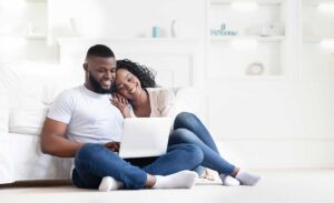 A couple and a real estate agent review documents at a kitchen table on closing day.